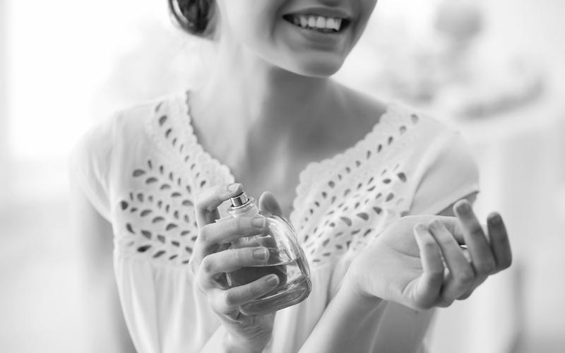 Eine Frau hält eine Parfümflasche in der Hand
