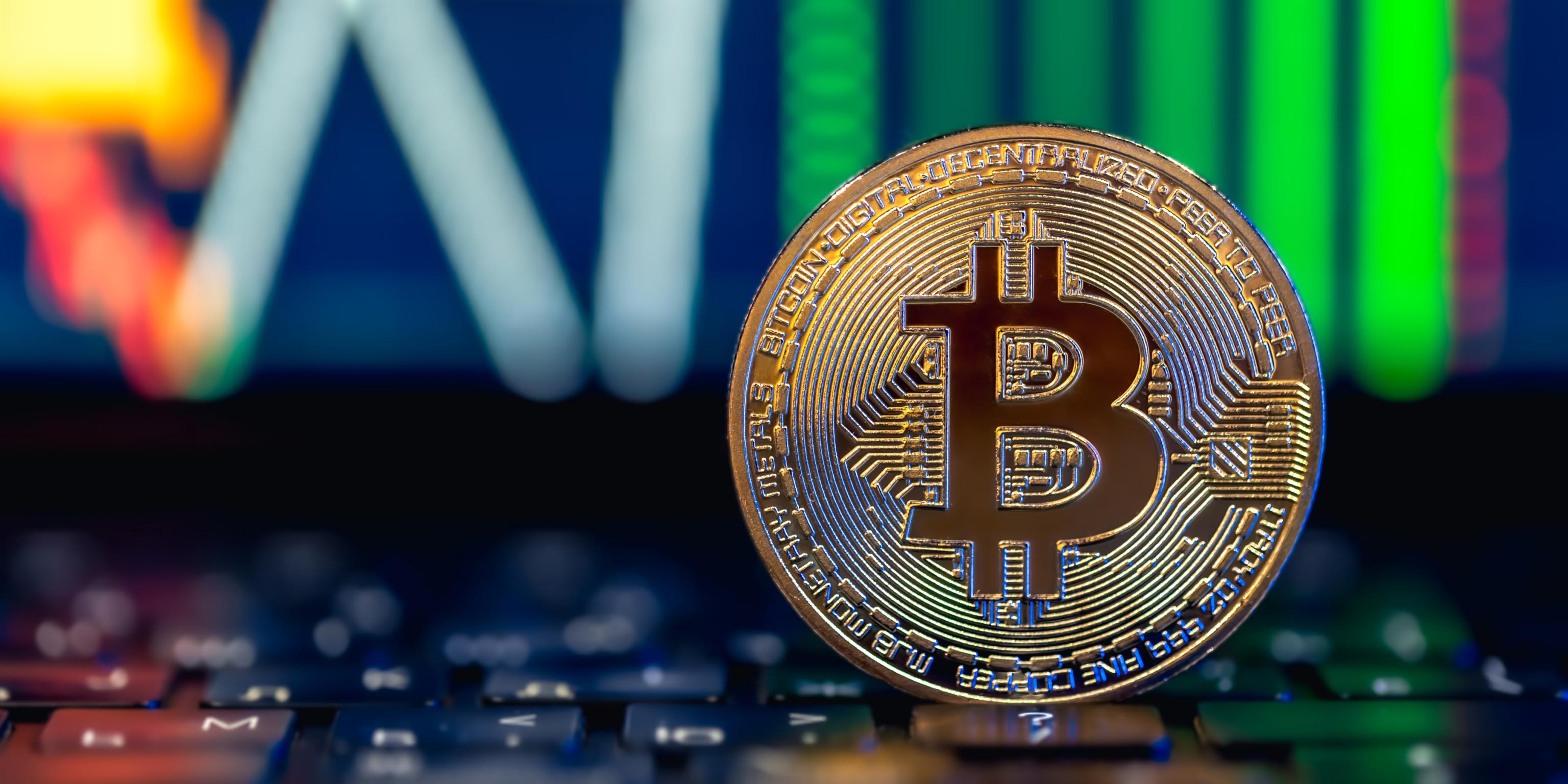 eine Bitcoin-Münze steht auf einer Glasplatte
